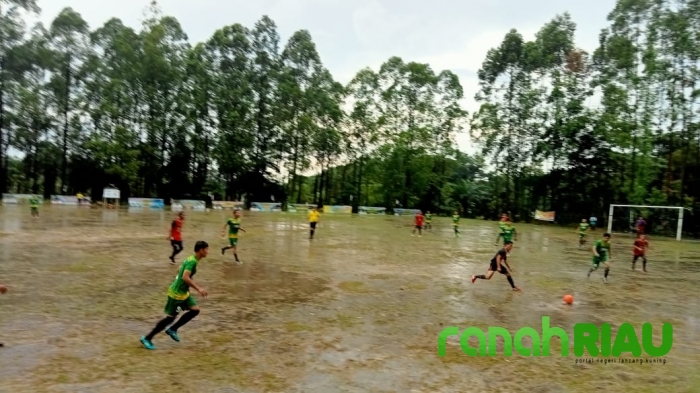 Guyuran hujan ditengah suasana pertandingan tidak surutkan semangat pemain untuk cetak Gol